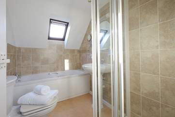 The family bathroom has a bath and a walk in. shower.