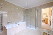 The en suite bathroom for Bedroom 1 has a rainfall shower and bath.