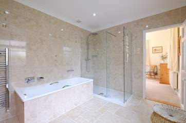 The en suite bathroom for Bedroom 1 has a rainfall shower and bath.
