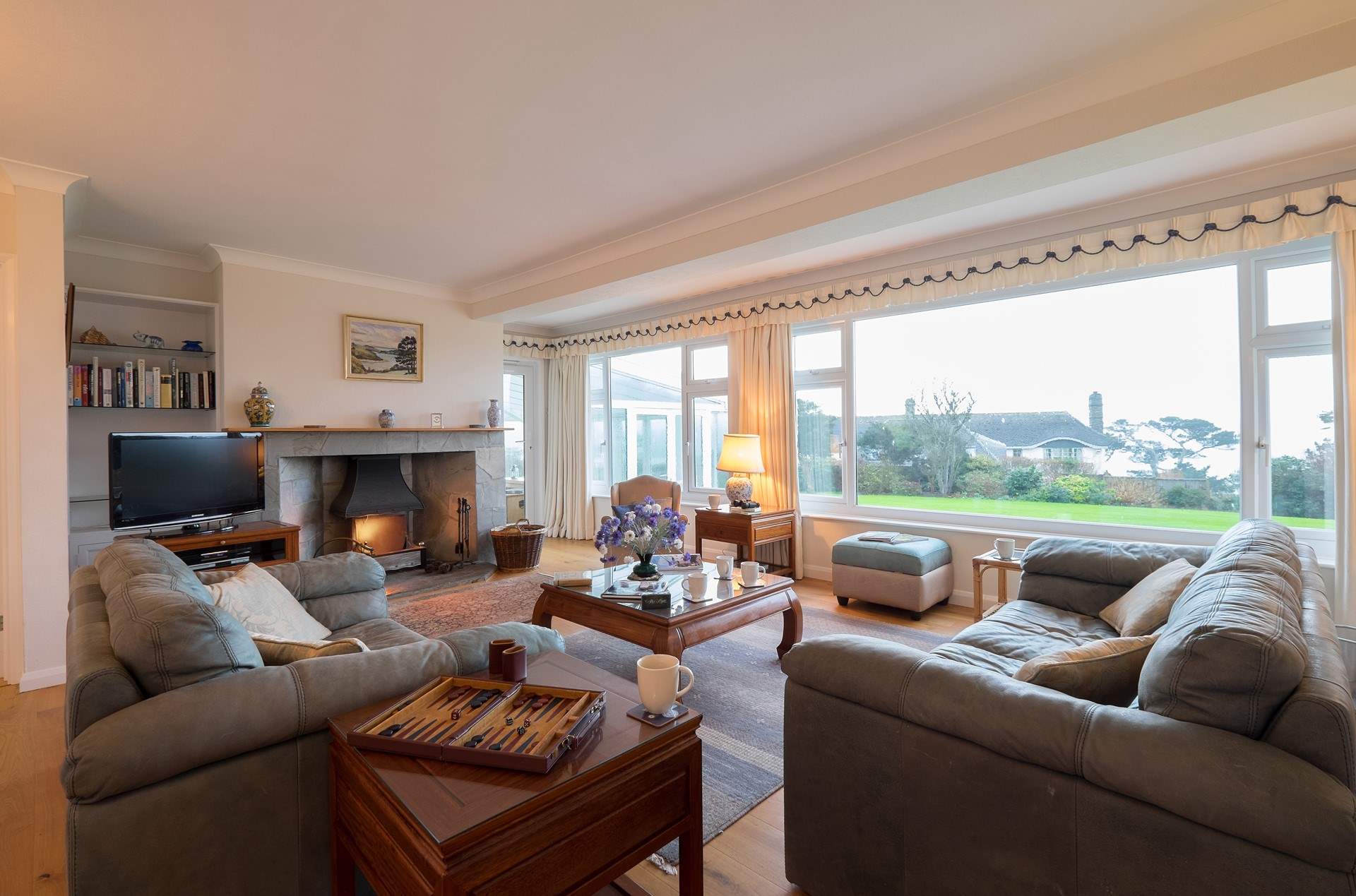 The sitting-room has panoramic views of the lovely garden. Please note the fireplace is ornamental only. 