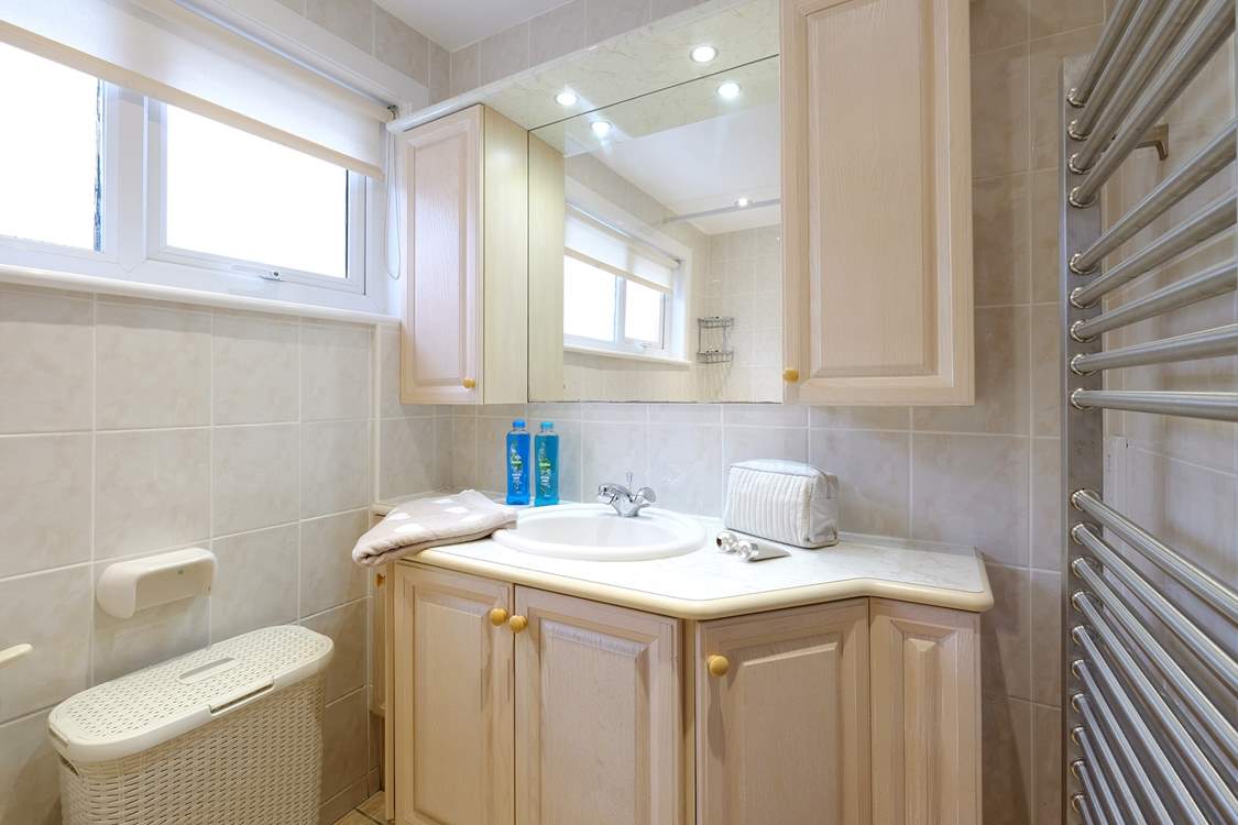 The bathroom has a bath with fitted shower over.