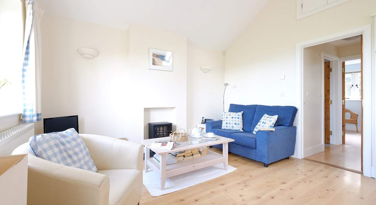 The light and bright sitting-room has an electric effect wood-burner.