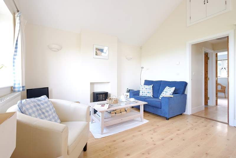 The light and bright sitting-room has an electric effect wood-burner.