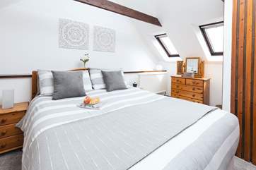 The main bedroom with muted natural tones and a king size bed.