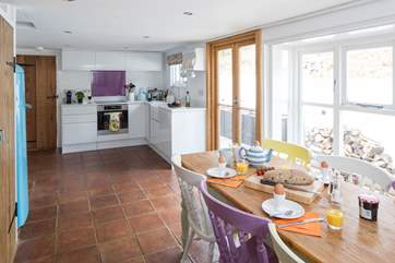 The open plan kitchen and dining-room is a very sociable space and has French doors onto a sheltered patio-area.