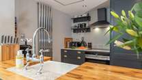 The well-equipped modern kitchen has all you need to conjur up something delicious; beyond is the downstairs shower-room.