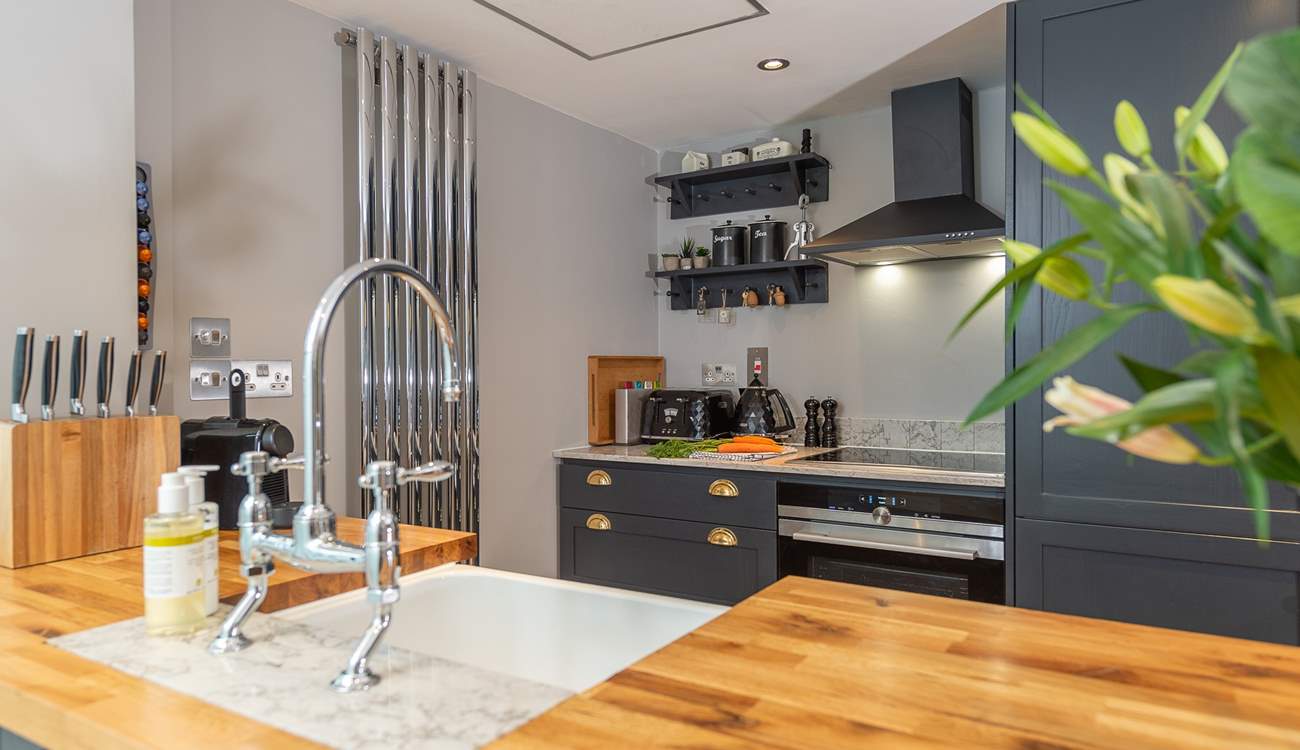 The well-equipped modern kitchen has all you need to conjur up something delicious; beyond is the downstairs shower-room.