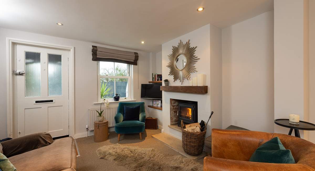 The sitting-area has luxurious furnishings and a cosy wood-burner, perfect for relaxing with a good book or a glass of wine.