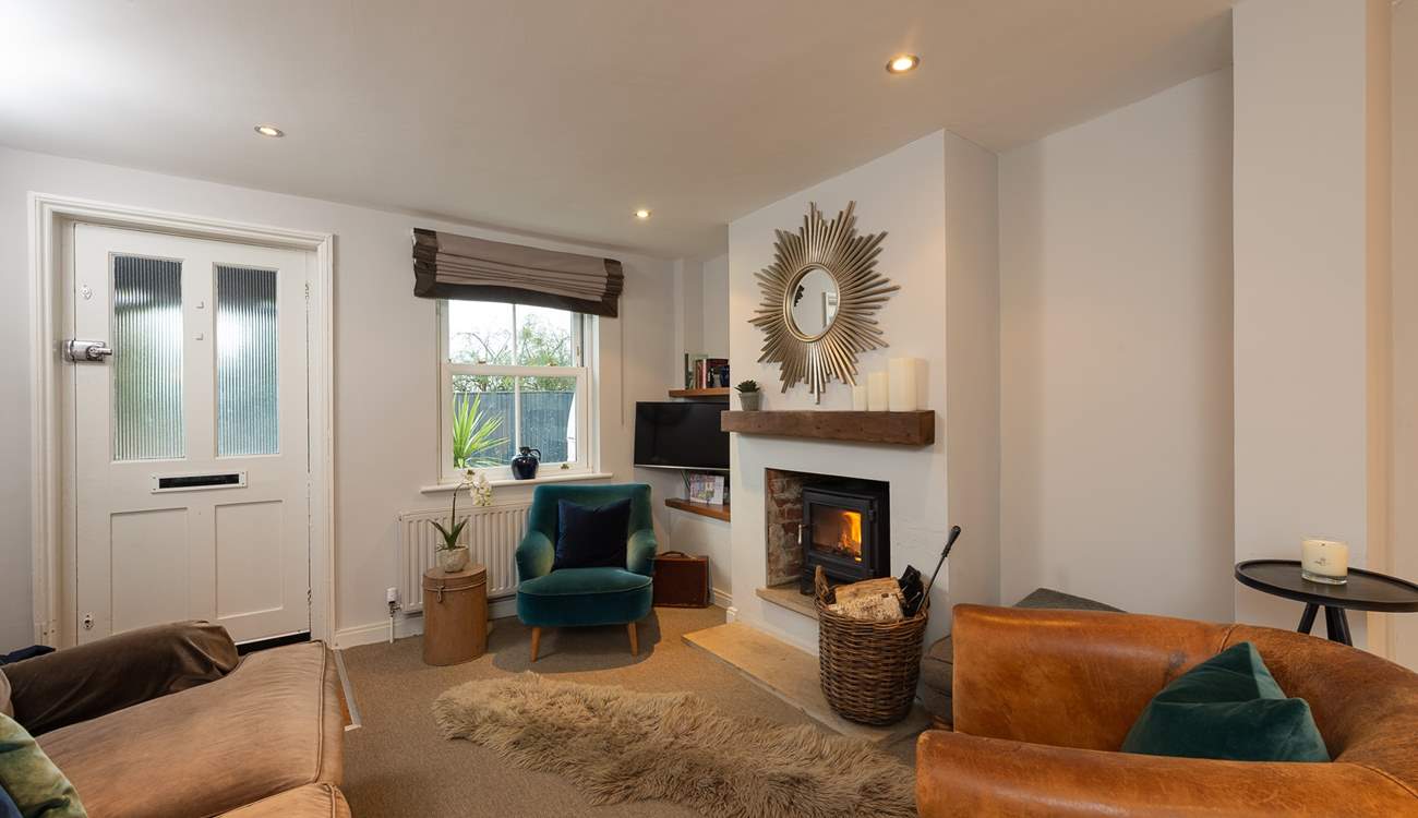 The sitting-area has luxurious furnishings and a cosy wood-burner, perfect for relaxing with a good book or a glass of wine.