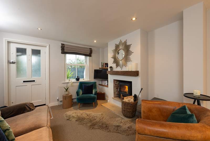 The sitting-area has luxurious furnishings and a cosy wood-burner, perfect for relaxing with a good book or a glass of wine.