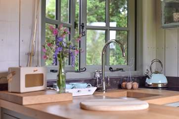 The kitchen is handcrafted and has an outlook over the small copse behind.