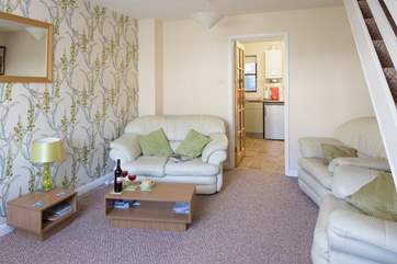 Cosy and comfortable living room, which leads into the kitchen. The stairs lead up to the first-floor bedrooms and bathroom.
