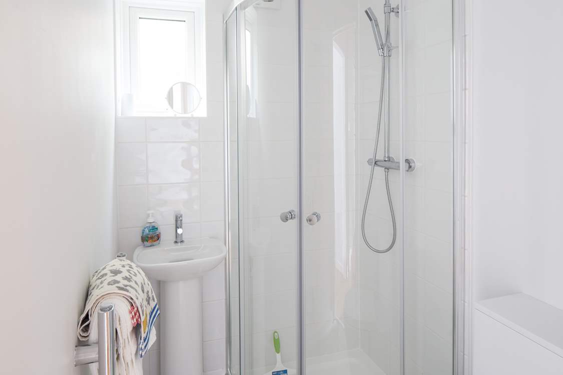 The en suite to the main bedroom is very compact with a drench head shower and petite hand basin.