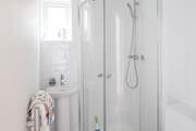 The en suite to the main bedroom is very compact with a drench head shower and petite hand basin.