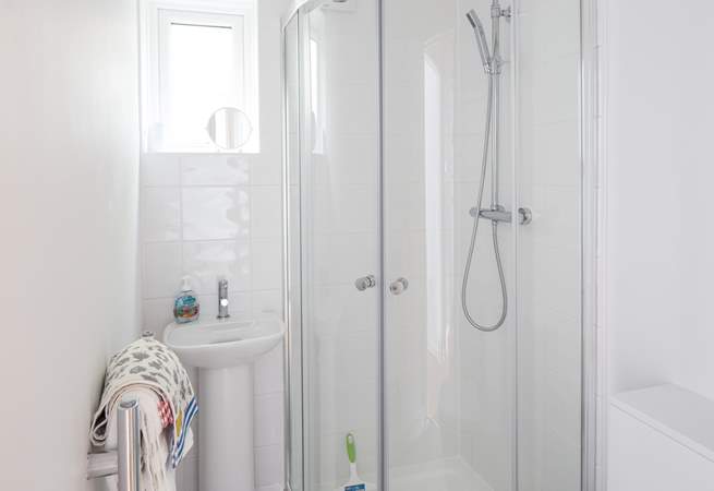 The en suite to the main bedroom is very compact with a drench head shower and petite hand basin.