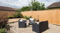 The back garden is fully enclosed with comfy garden seating in addition to a table and chairs.