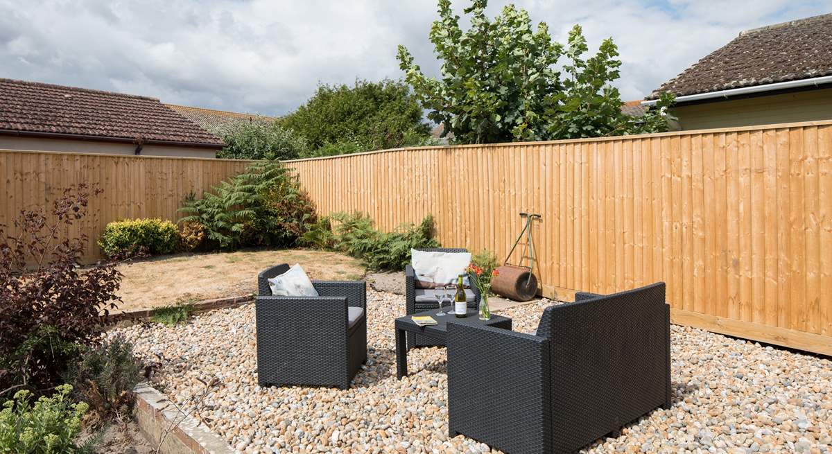 The back garden is fully enclosed with comfy garden seating in addition to a table and chairs.