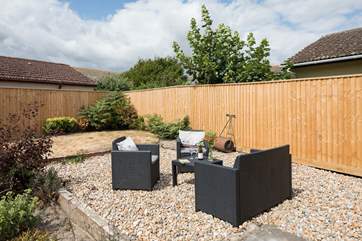The back garden is fully enclosed with comfy garden seating in addition to a table and chairs.