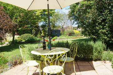 A sunny patio is tucked away behind the Coach House. It overlooks the lovely gardens here and feels nice and private.