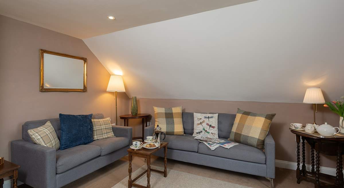 The cosy first floor sitting-room has two comfortable sofas and wonderful views.