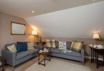 The cosy first floor sitting-room has two comfortable sofas and wonderful views.