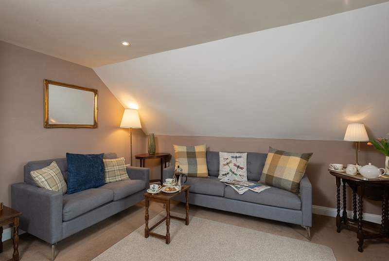 The cosy first floor sitting-room has two comfortable sofas and wonderful views.