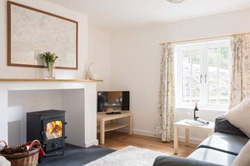 The sitting end of the open plan living room has the sofas around the wood-burner.