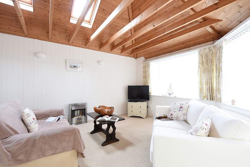 The cosy sitting-room has French doors  which open onto the sun deck.