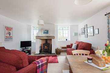 The welcoming living-room with sitting and dining-area and a warming wood-burner.