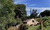 Looking down from the field above to the patio area outside the cottage. - Thumbnail Image