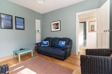 A comfortable place to relax. Two steps lead up from the sitting-room to the kitchen and conservatory.