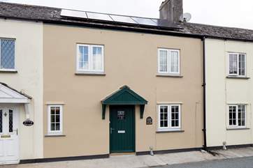 The cottage front featuring solar panels.