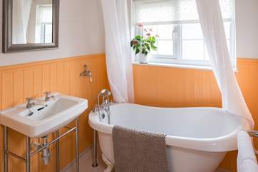The cheerful bathroom, with a roll-top bath, perfect for unwinding in after a long day.