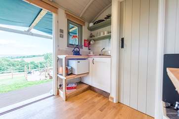 With a sweet little kitchen-area with a small fridge and toaster.