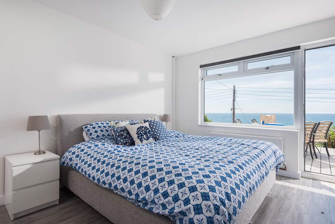 The fabulous master bedroom is located on the lower ground floor and has a door out onto the garden decking.