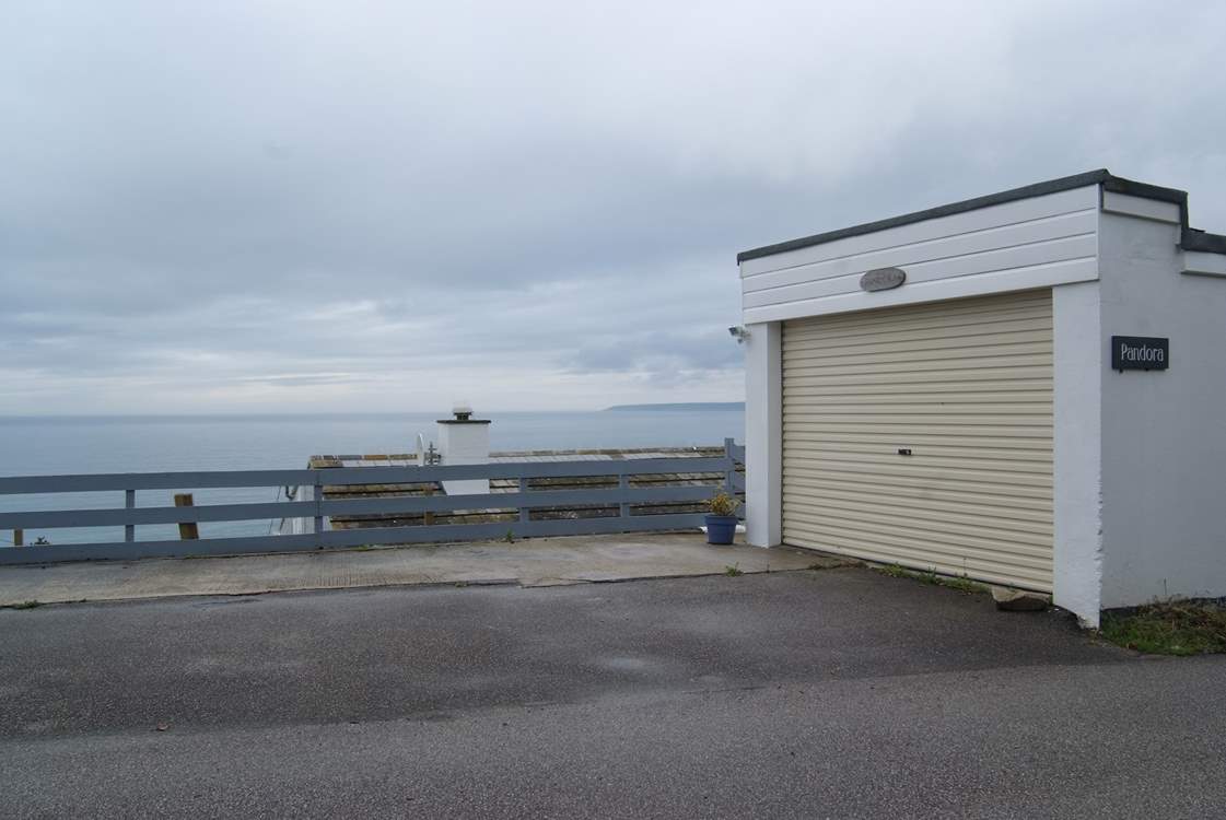 There is parking for two cars in front of the garage with steps to the house in the far corner.