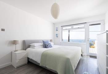 The fabulous main bedroom is located on the lower ground floor and has a door out onto the garden decking.