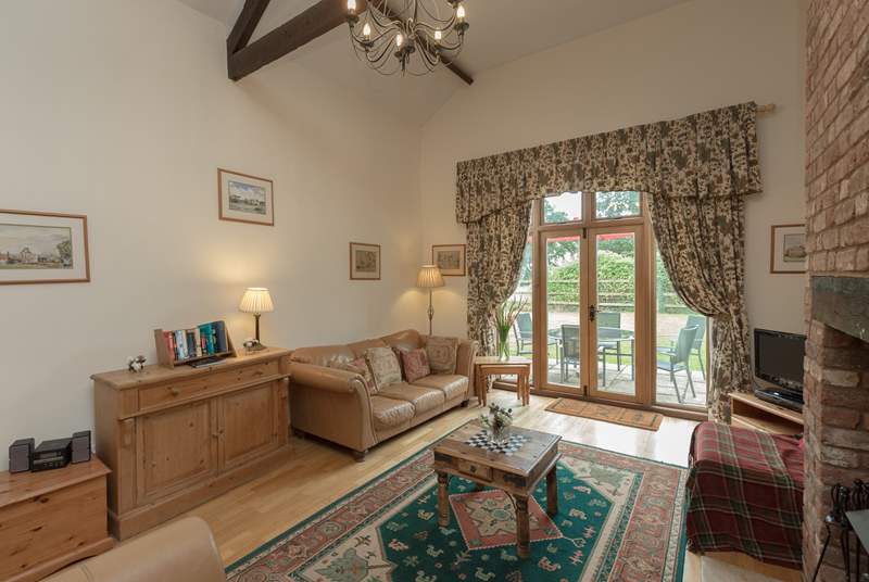 The living room has French windows to the patio and the large enclosed garden beyond.