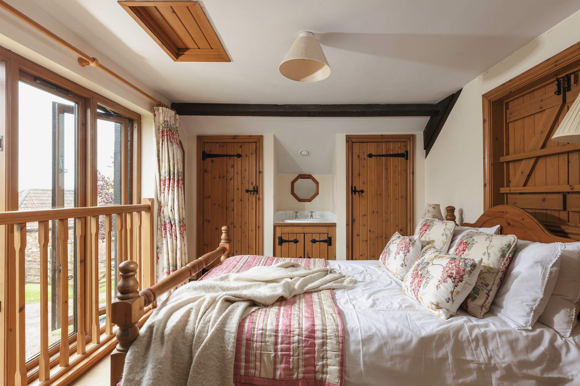 The master bedroom is on the mezzanine level with views out to the front of the cottage and a little secret window over the living room.