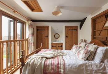 The master bedroom is on the mezzanine level with views out to the front of the cottage and a little secret window over the living room.