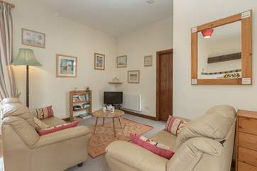 This is the cosy living room part of the open plan ground floor. The door in the photograph is to the main bedroom