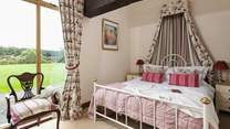 The pretty main bedroom has a view of the garden.