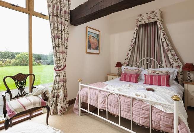 The pretty main bedroom has a view of the garden.