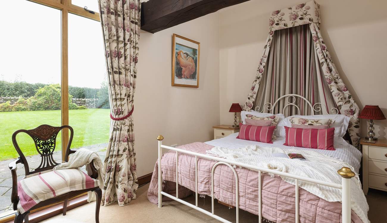 The pretty main bedroom has a view of the garden.