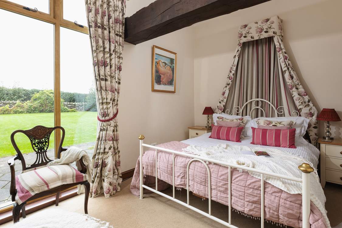 The pretty main bedroom has a view of the garden.