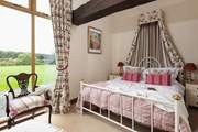 The pretty main bedroom has a view of the garden.