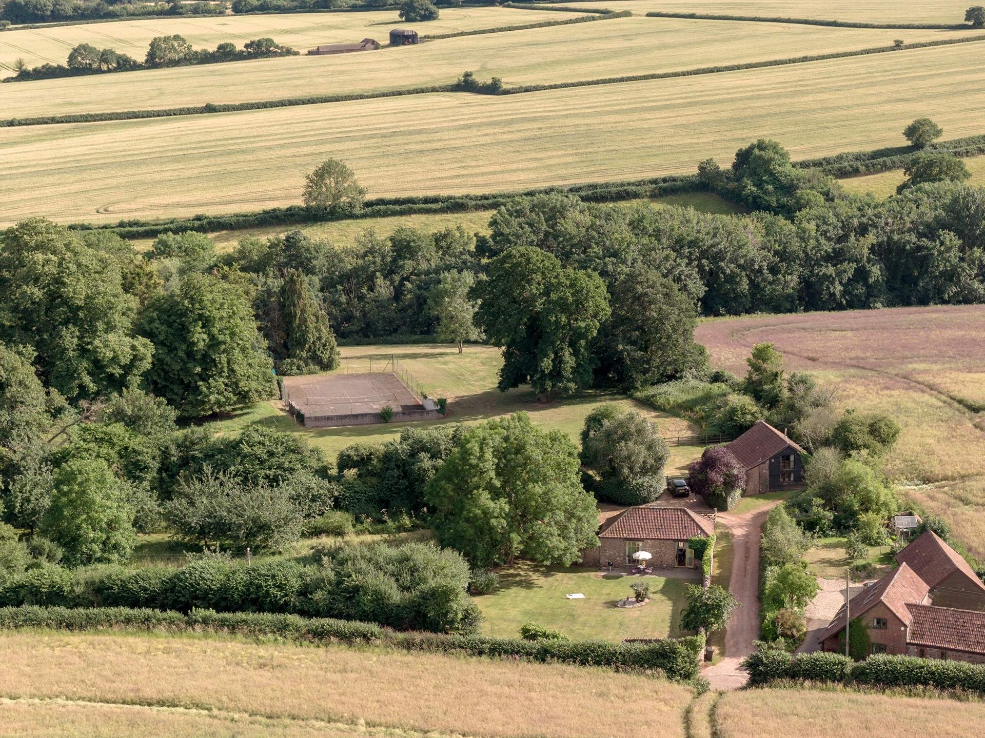 To give a sense of scale, the grounds spread out behind and to the right of Orchard Barn with a view of the tennis court in the distance...