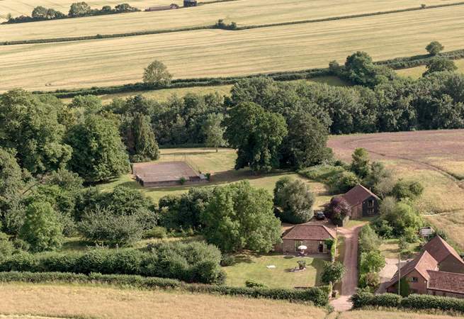 To give a sense of scale, the grounds spread out behind and to the right of Orchard Barn with a view of the tennis court in the distance...