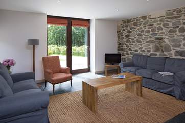The seating area has floor to ceiling glazed patio doors.