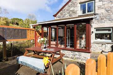 Sit outside and listen to the birdsong and the bubbling stream that runs next to the cottage (please note the picnic bench is now at the front of the house and a corner rattan sofa is in its place).